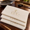 Illustrative custom restaurant branding on disposable paper napkins